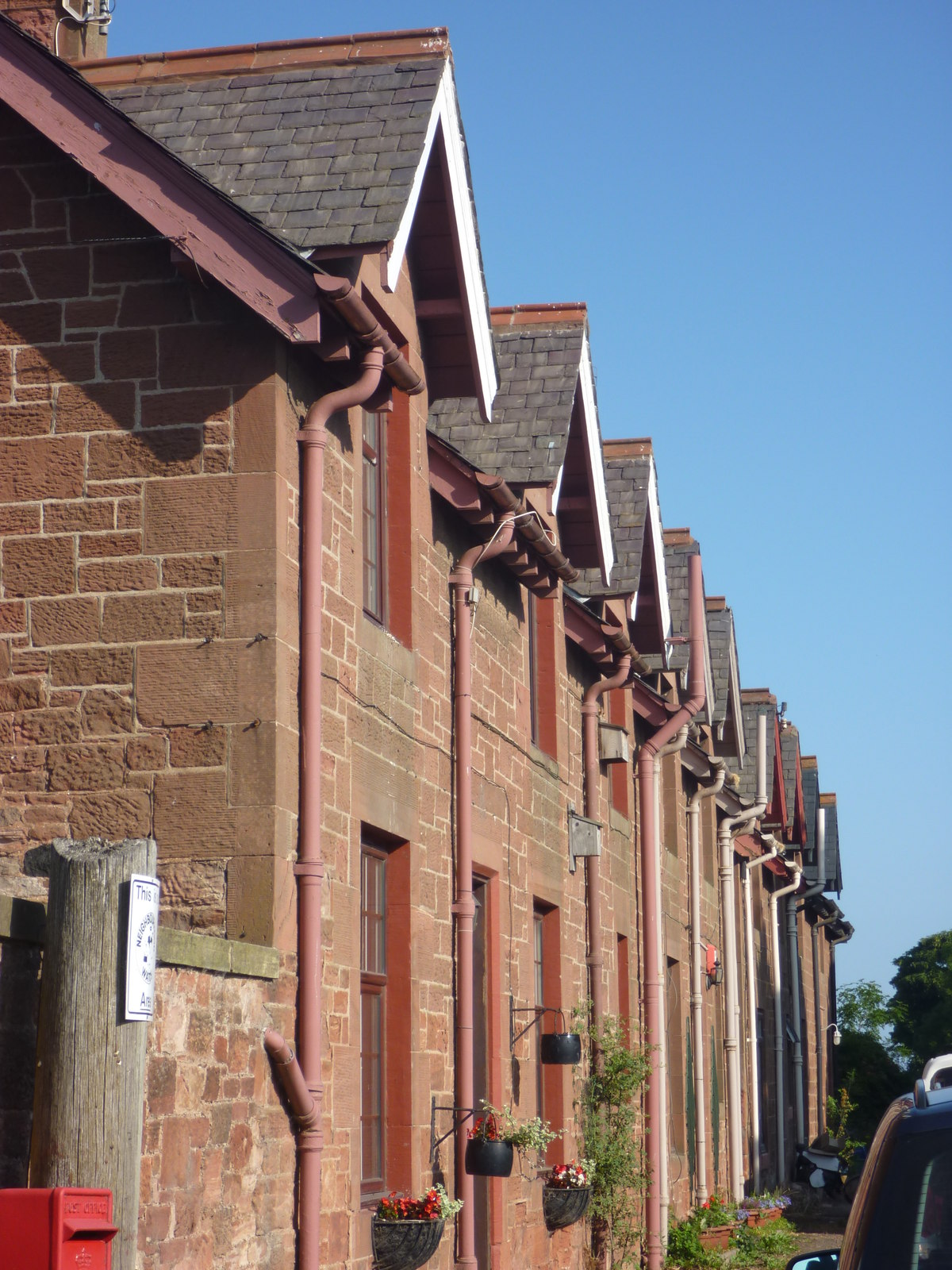 Gutter and downpipe connection along a roofline.